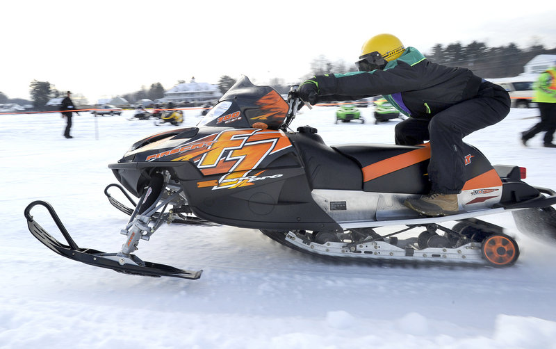 A snowmobile racer zooms across the ice in a radar run Saturday at the Naples Winter Carnival, which continues today.