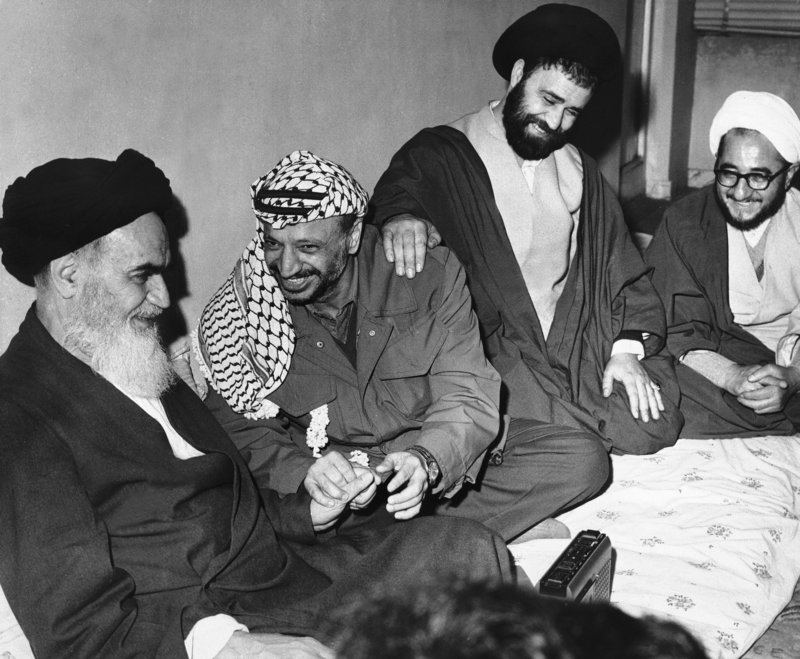 Ayatollah Ruhollah Khomeini, left, smiles with Palestinian leader Yasser Arafat in Tehran. The Ayatollah's son has his hand on Arafat's shoulder. The uprising that toppled the shah of Iran took a year, paralyzed the country and grew violent.
