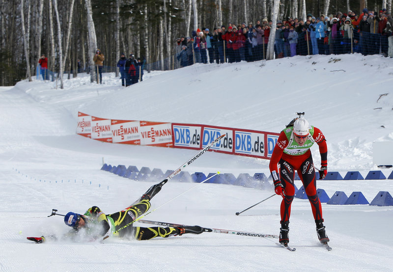 Martin Fourcade of France tumbles as he tries to beat Norway’s Emil Hegle Svendsen to the finish line in the 12.5-kilometer pursuit Saturday in the World Cup biathlon at Fort Kent. A finish-line photo showed Svendsen’s ski getting there first.