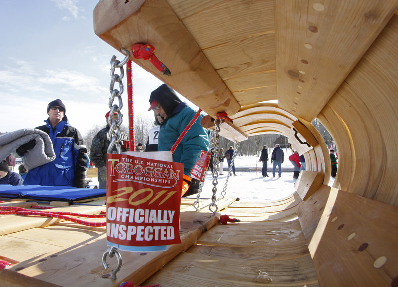 Sledders get a tag for their toboggan after it has been inspected and deemed ready to ride in the championships on Saturday.