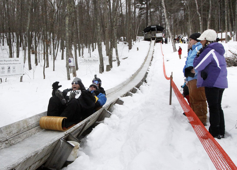 Coby Lerner of Baltimore, Md., screams as he races down the track with his father Mark and brother Tyler, in back, during the 21st annual U.S. National Toboggan Championships in Camden on Saturday. Some sledders believe that screaming during the run can make them go faster.