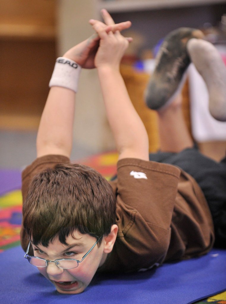 Danny Tocci works on a position during a yoga class at Riverton Elementary School.