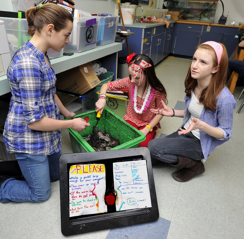 Charlotte Eisenberg, right, talks about her project for composting as students, Hattie Train, left, and Imogen Moxhay, middle, help show the worm farm in a King Middle School classroom. Eisenberg, an eighth-grader, is one of two Maine winners of a national Prudential Spirit of Community Award.