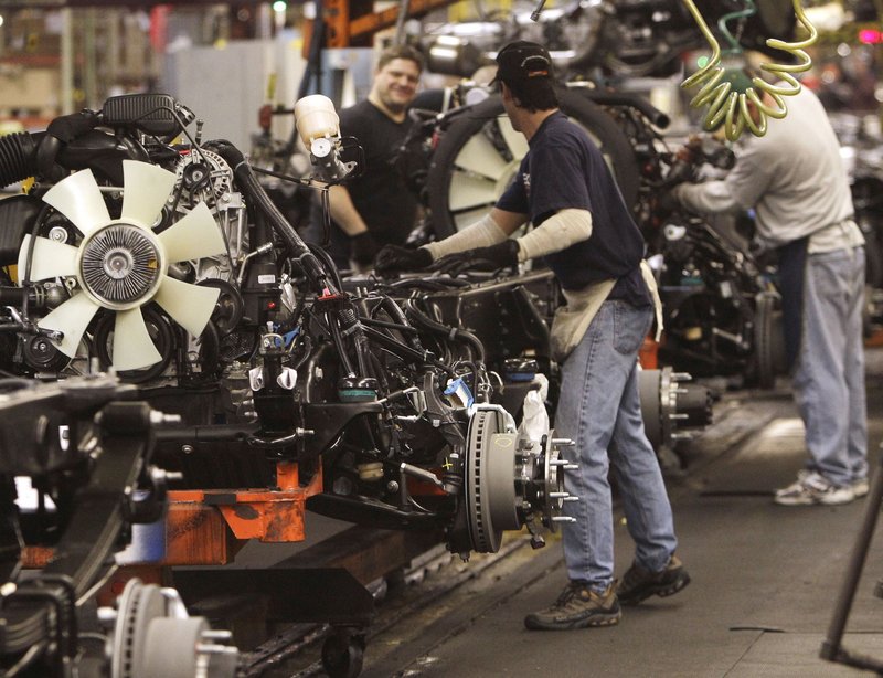 Workers attach engines to chassis for Silverado and Sierra pickups at the GM assembly plant in Flint, Mich. GM disclosed Monday that it will pay $189 million in bonuses to 48,000 U.S. hourly workers.