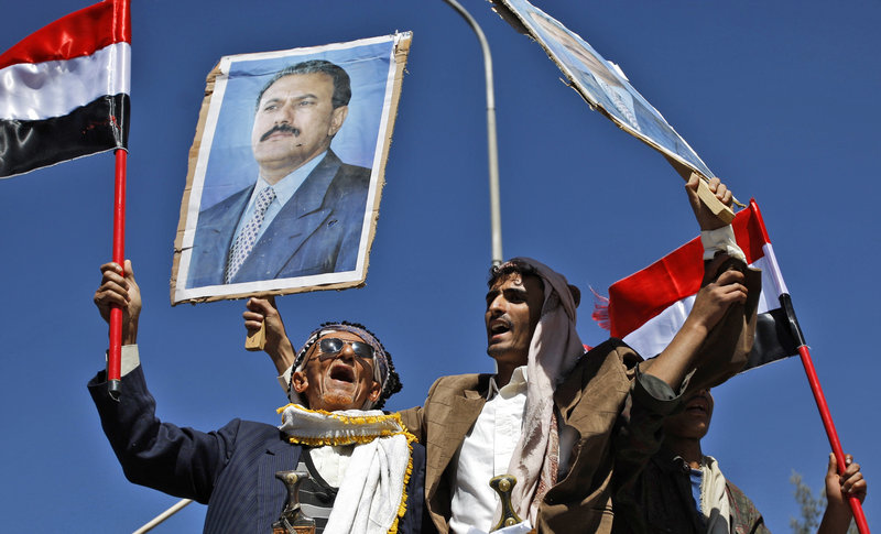 Supporters of the government wave flags and raise posters of President Ali Abdullah Saleh in Sanaa, Yemen, on Tuesday, while a thousand anti-government protesters also marched.