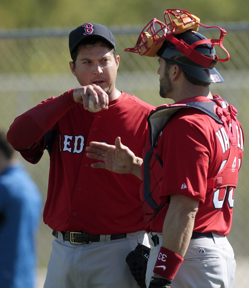 Josh Beckett, left, talks with catcher Jason Varitek at the Boston Red Sox player development complex in Fort Myers, Fla., Tuesday. It was the first official spring training workout for pitchers and catchers.