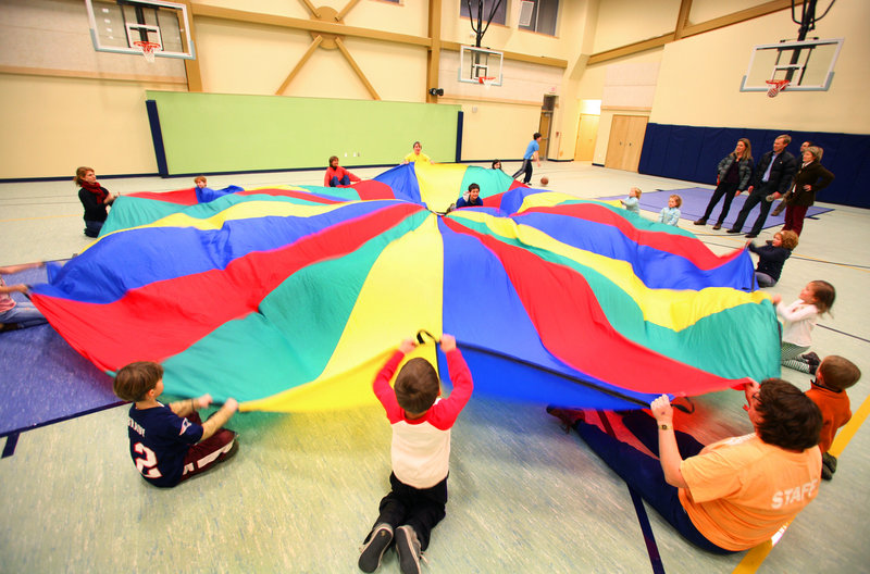 Some of the visitors to Wednesday's open house get to play parachute games in the gym of the new Ocean Avenue Elementary School in Portland.