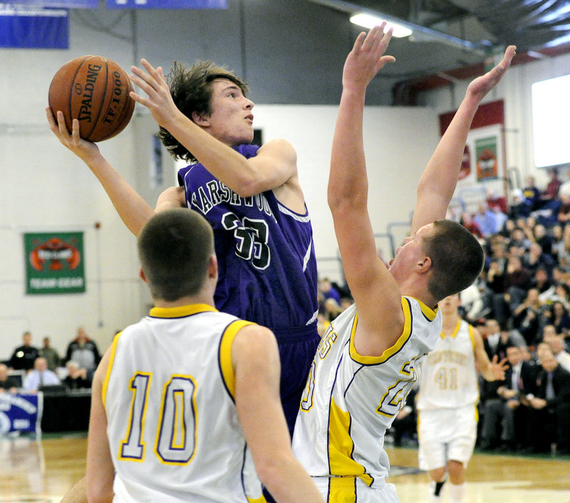 Matthew Crosby of Marshwood looks for a way to get the ball to the basket Friday night while guarded by Cam Olson of Cheverus as Connor O’Neil moves in. Cheverus was challenged before pulling away to a 52-40 victory.