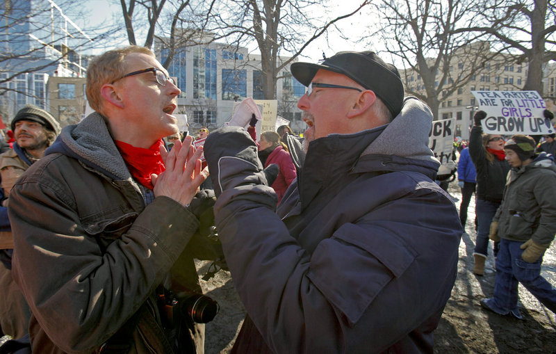 A union advocate, left, and a Tea Party supporter argue in Madison, Wis., on Saturday, over the governor's proposed budget bill.