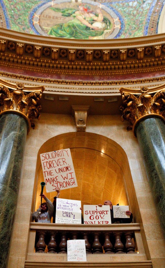 Critics of the governor's bill to eliminate collective bargaining rights for many state workers and supporters of the governor demonstrate at the State Capitol in Madison, Wis., on Sunday.