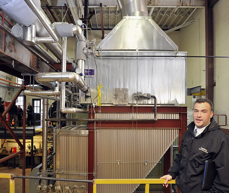 John Simoneau, capital projects manager in the facilities department at Bowdoin College in Brunswick, points out an addition to the campus’ steam heating system that recovers heat from the boiler’s exhaust, part of an overall commitment by the school to become carbon neutral by 2020.