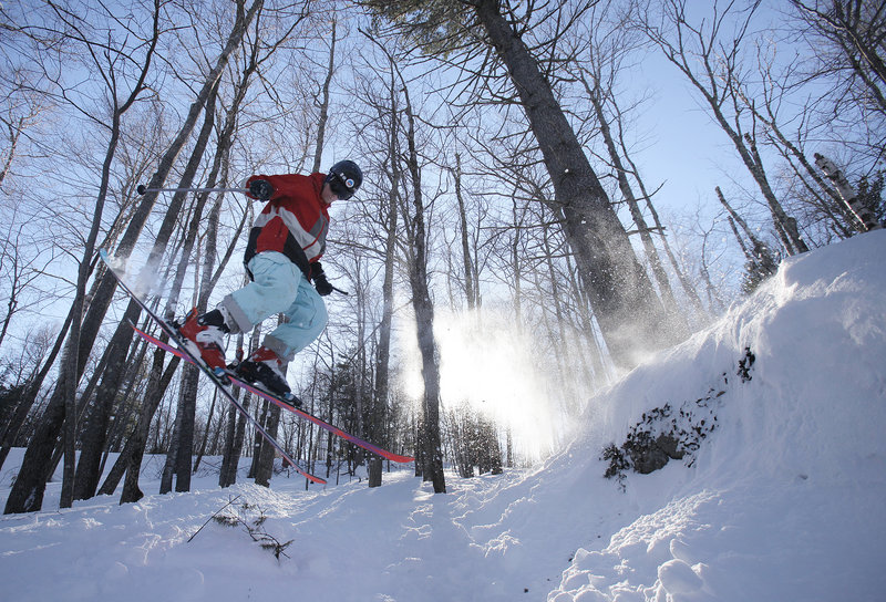 Derek Drechsler skis off a snow-covered rock. The mountain added three new glades this past fall.