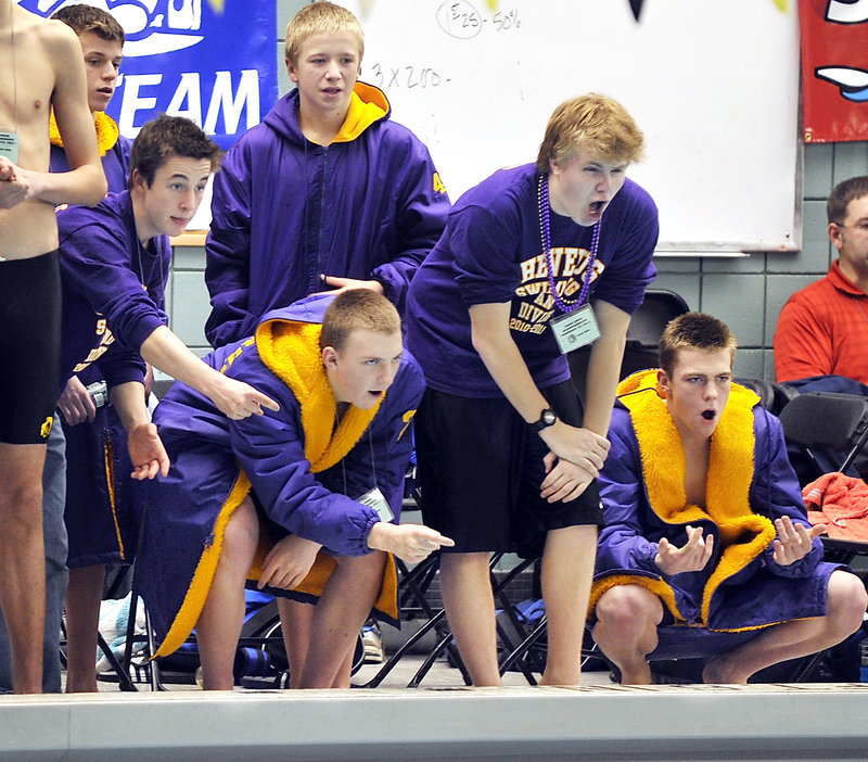 Cheverus teammates cheer on Reed Fernandez as he swims in the trials of the 200-yard individual medley.