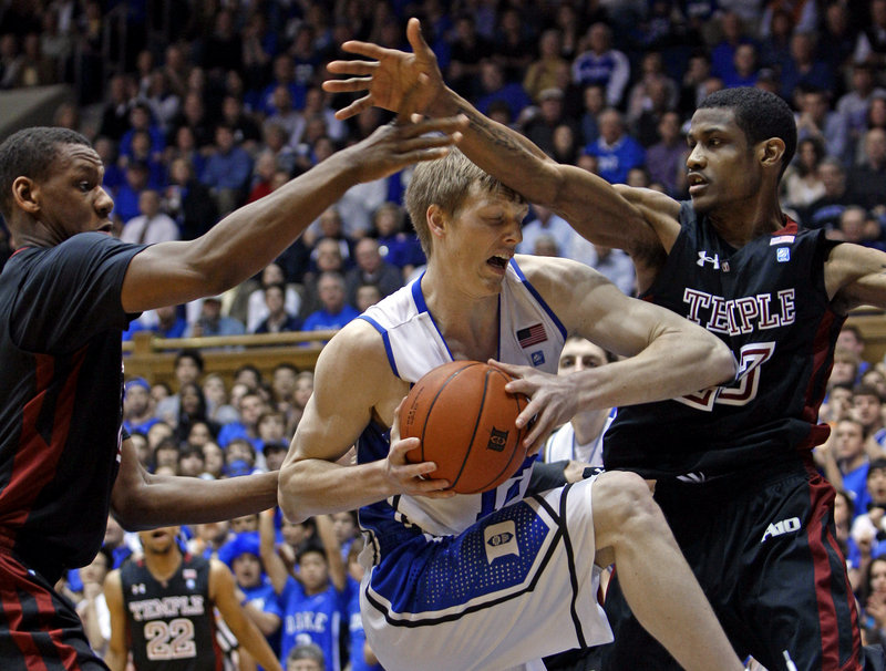 Kyle Singler of Duke tries to drive between Temple’s Lavoy Allen, left, and Ramone Moore during their game Wednesday night at Durham, N.C. Singler had 28 points to lead top-ranked Duke to a 78-61 victory.