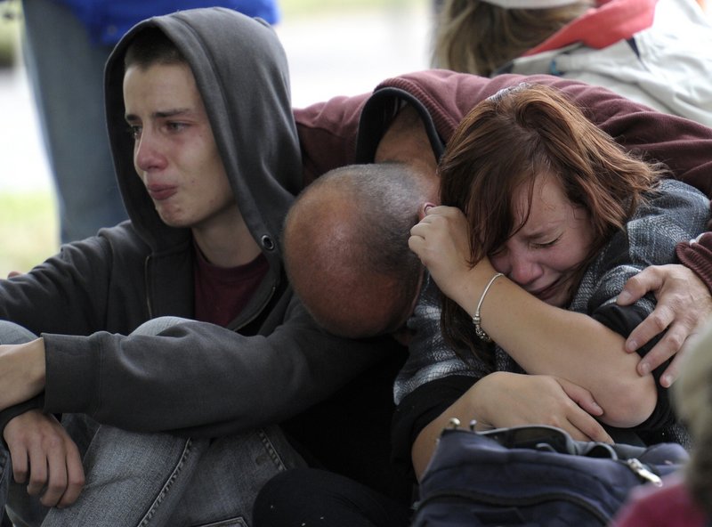 Fifteen-year-old Kent Manning, left, and his sister Lizzy, 18, react Wednesday with their father, who asked not to identified, after being told there was no hope that Kent and Lizzy’s mother would be found alive in a building that collapsed during a 6.3-magnitude earthquake Tuesday. Authorities said the death toll would be “significant.’
