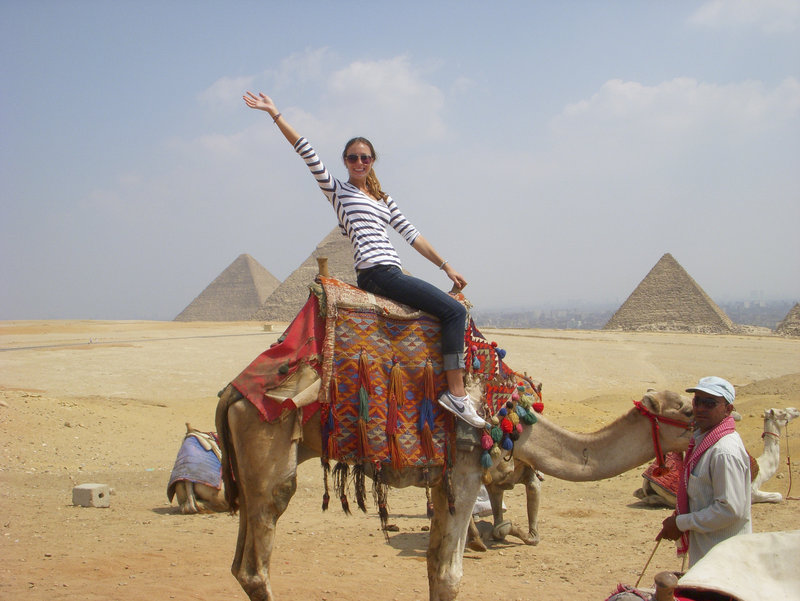 Maja Bedak, a University of Maine student from Portland, rides a camel near the pyramids in Egypt while studying last semester at The American University in Cairo.