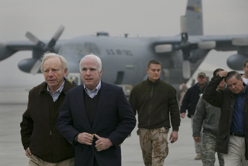 U.S. Sen. Joseph Lieberman, I-Conn., left, walks with Sen. John McCain at the Kabul airport in December 2008. Lieberman and McCain were among the senators allegedly targeted for manipulation by “psy-ops” units in Afghanistan.