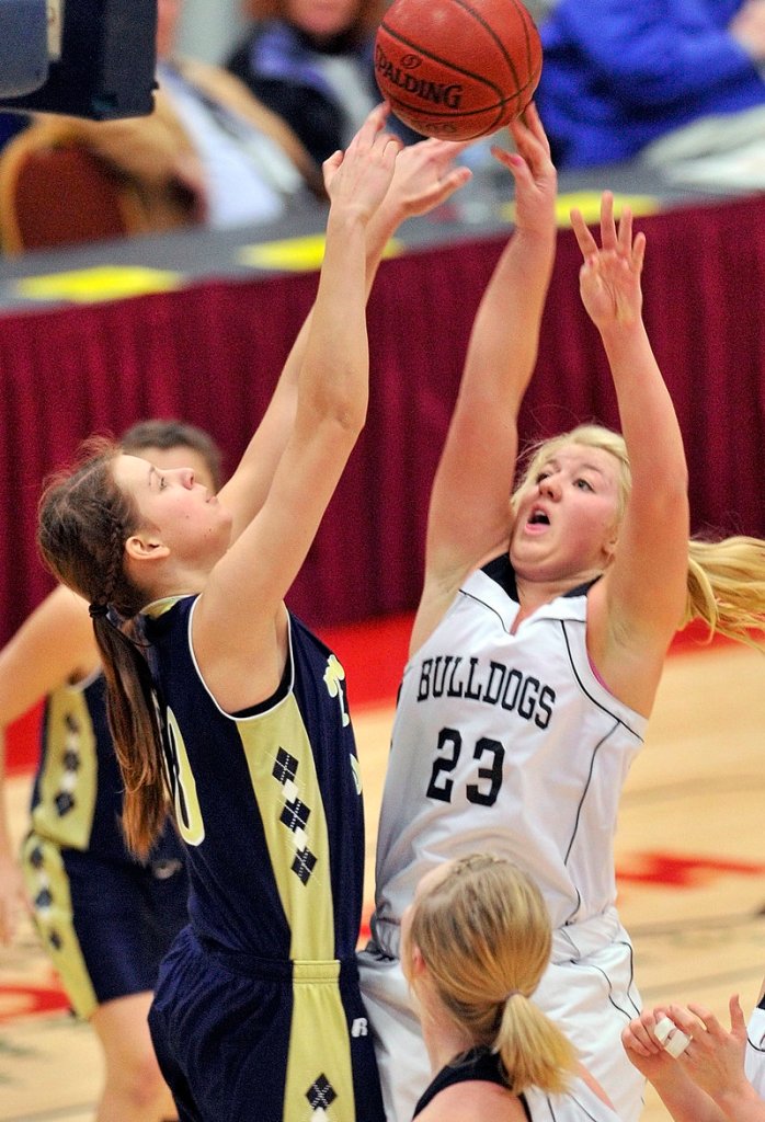 Carylanne Wolfington, right, of Hall-Dale barely gets the ball over Carolin Reinke of Traip Academy during Hall-Dale s 45-36 victory in their Western Class C semifinal at Augusta.