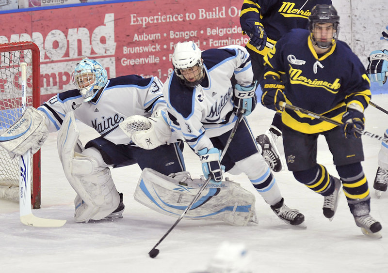 Maine goalie Dan Sullivan scurries back to his net Friday night as Mark Nemec clears the puck away from Brandon Brodhag of Merrimack. Sullivan earned a third straight shutout and is fewer than 14 minutes from Jimmy Howard’s school record for minutes without allowing a goal.