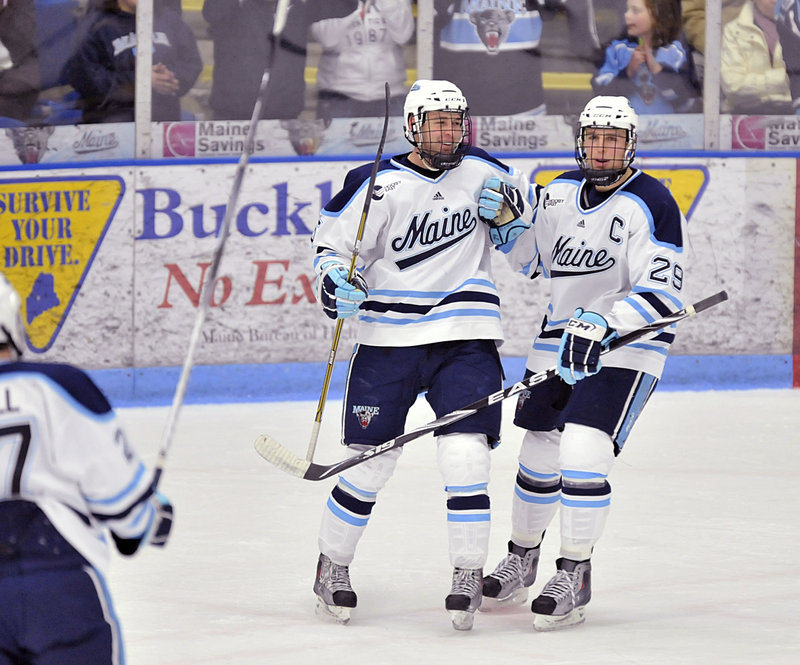 Josh Van Dyk, left, and Tanner House celebrate after Van Dyk scored in the first period – his first goal of the season – to give Maine a 2-0 lead.