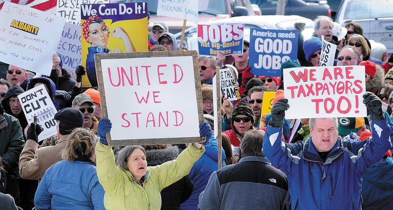Demonstrators singing union songs and carrying signs gather in a parking lot on the south side of the State House in Augusta on Saturday. The rally was partly a reaction Gov. Paul LePage’s proposal to reduce pension benefits for retired state employees and teachers, and partly to support unionized state workers in Wisconsin.