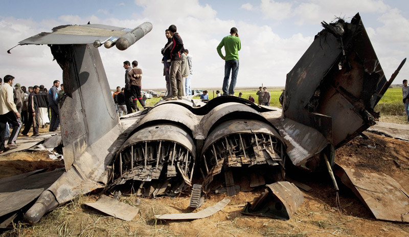 Libyans inspect the wreckage of a US F15 fighter jet after it crashed in an open field in the village of Bu Mariem, east of Benghazi today. The U.S. Africa Command said both crew members were safe after what was believed to be a mechanical failure of the Air Force F-15. The aircraft, based out of Royal Air Force Lakenheath, England, was flying out of Italy's Aviano Air Base.