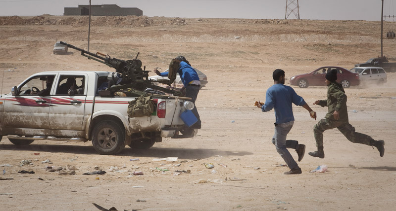 Libyan rebels flee as shellis from Gadhafi's forces start landing on the front line outside of Bin Jawaad, Libya, today.