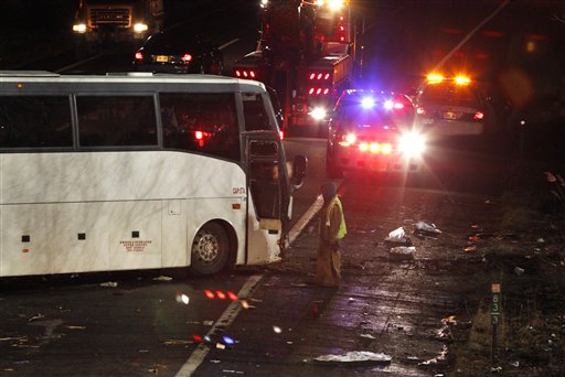 In this March 15, 2011, file photo, a worker is seen next to a luxury bus that crashed on Exit 9 of the southbound New Jersey Turnpike, in East Brunswick, N.J. Deadly bus crashes over the past decade have claimed dozens of lives, including college baseball players in Atlanta, Vietnamese Catholics in Texas, skiers in Utah and, this month, gamblers returning to New York's Chinatown.