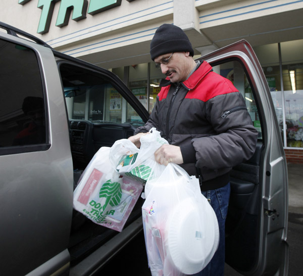 Larry Buckley leaves a Dollar Tree store in Batavia, N.Y. Consumer spending rises at fastest pace since October, led by purchases of autos and gasoline.