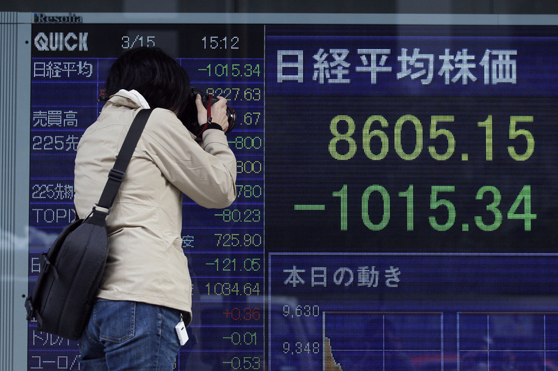 A photographer takes a photo of a stock price board in a street on Tuesday in Tokyo, Japan. Japan's Nikkei stock index nose-dived nearly 11 percent Tuesday as the earthquake-shattered country faced an unfolding nuclear crisis. 9.0 Magnitude Earthquake,Destruction,Devastation,Disaster,Earthquake,people,person,Ruin,Sendai Earthquake and Tsunami