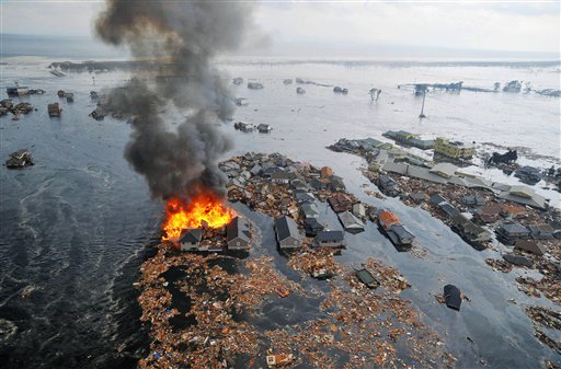 Part of houses swallowed by tsunami burn in Sendai, Miyagi Prefecture (state) after Japan was struck by a strong earthquake off its northeastern coast Friday, March 11, 2011. (AP Photo/Kyodo News) JAPAN OUT, MANDATORY CREDIT, FOR COMMERCIAL USE ONLY IN NORTH AMERICA ?u?J??n?[?v