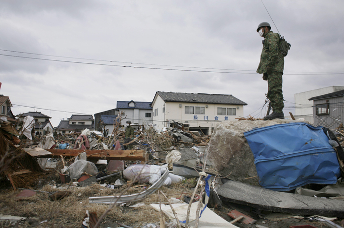A member of Japan's Self-Defense Force surveys the damage in Soma, Fukushima prefecture.
