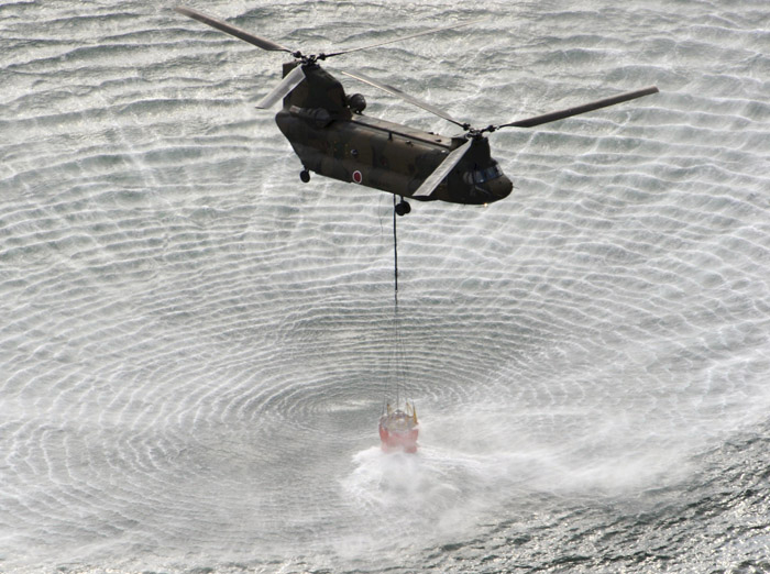 A Japanese Self-Defense Forces helicopter scoops water off Japan's northeast coast on its way to the Fukushima Dai-ichi nuclear power plant in Okumamachi this morning.