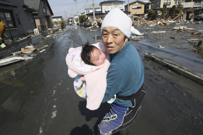 Upon hearing another tsunami warning today, a father tries to flee for safety with his just reunited baby girl who was found by a rescuer in the rubble of tsunami-torn Ishinomaki.
