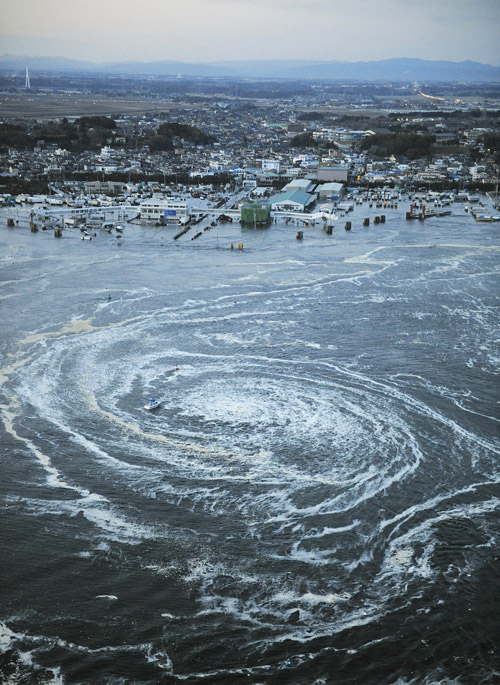 Tsunami waves swirl near a port in Oarai, Ibaraki Prefecture today.