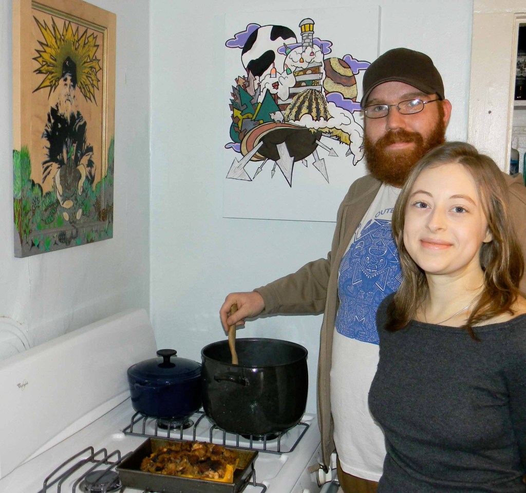 Luke Fuller and Cassi Madison prepare a chili using all Maine ingredients in their West End kitchen. For the past year, the recently engaged couple has made an effort to eat only food from Maine. Fuller, who is an artist, created the artwork above the stove. The piece on the left depicts the late Jim Cook, who founded the Crown O'Maine Organic Cooperative.