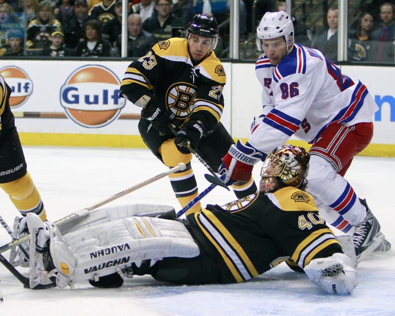 Bruins goalie Tuukka Rask smothers the puck as Wojtek Wolski of the Rangers looks for a rebound in today's game at Boston. The Rangers won, 1-0.