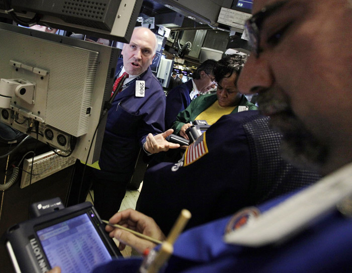 In this photo taken March 15, 2011, specialist Gerard Petti, left, directs trades at his post on the floor of the New York Stock Exchange. (AP Photo)