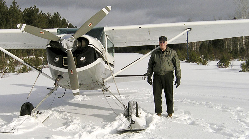 This January 2007 photo released by the Maine Department of Inland Fisheries and Wildlife shows Daryl Gordon standing next to his plane on a frozen lake.