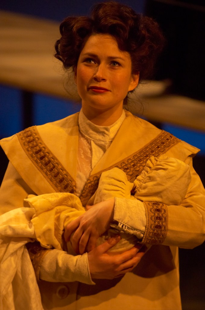 Margot (Sophia Holman), Orville Wright’s wife, cradles their newborn son in “The Center of Gravity” at Portland Stage.