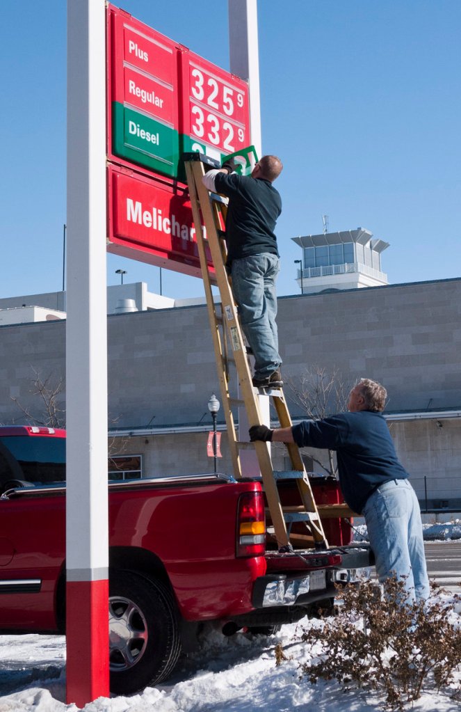 Gas station attendants in Lincoln, Neb., adjust the price of fuel upward in this February file photo.