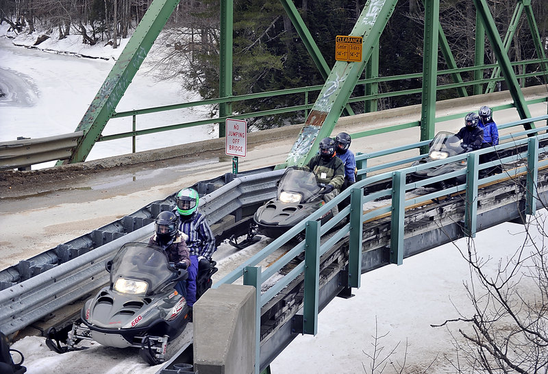 Snowmobile riders cross the Androscoggin River during a nearly four-hour excursion between Bethel and Gilead.