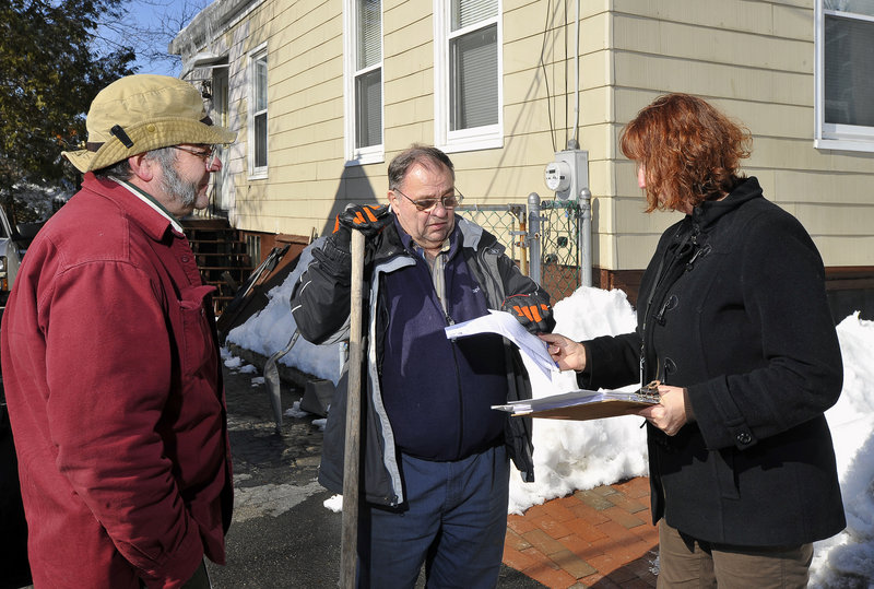 Dan McPherson, left, code enforcement officer for Portland, and Ronda Jones, right, a housing rehabilitation specialist, talk with East Bayside resident Robert Mehigan about increasing the energy efficiency of his home. The “Healthy Living, Healthy City” program helps finance such improvements.