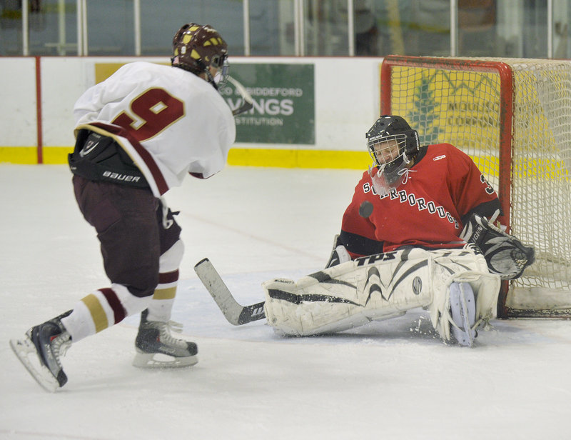 Scarborough goalie Doug Pitts blocks the puck with his chest as Jonathan Pate of Thornton Academy unleashes the shot during Thornton’s 6-0 victory at the Biddeford Ice Arena.