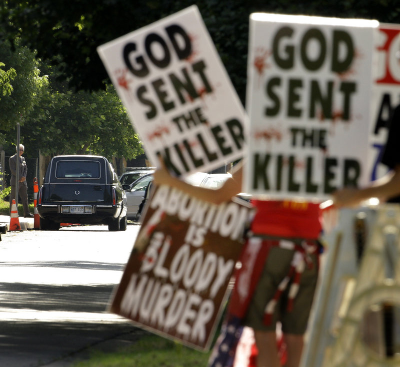 In this 2009 file photo, protesters from the Rev. Fred Phelps’ Westboro Baptist Church demonstrate during funeral services for Dr. George Tiller, a provider of late-term abortions, at College Hill United Methodist Church in Wichita, Kan.