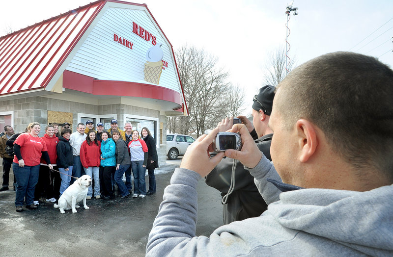 Seth Josef, son-in-law of Red’s owner Chris Bolling, takes a photo of family members and past and present workers as the ice cream stand reopened Friday in South Portland.