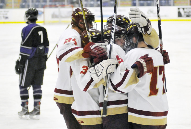 Robert Downing is swarmed by his Thornton Academy teammates after scoring a goal in the second period Saturday against Marshwood/Traip Academy in a Western Class A hockey semifinal. The Trojans advanced to the regional final with an 8-1 victory.