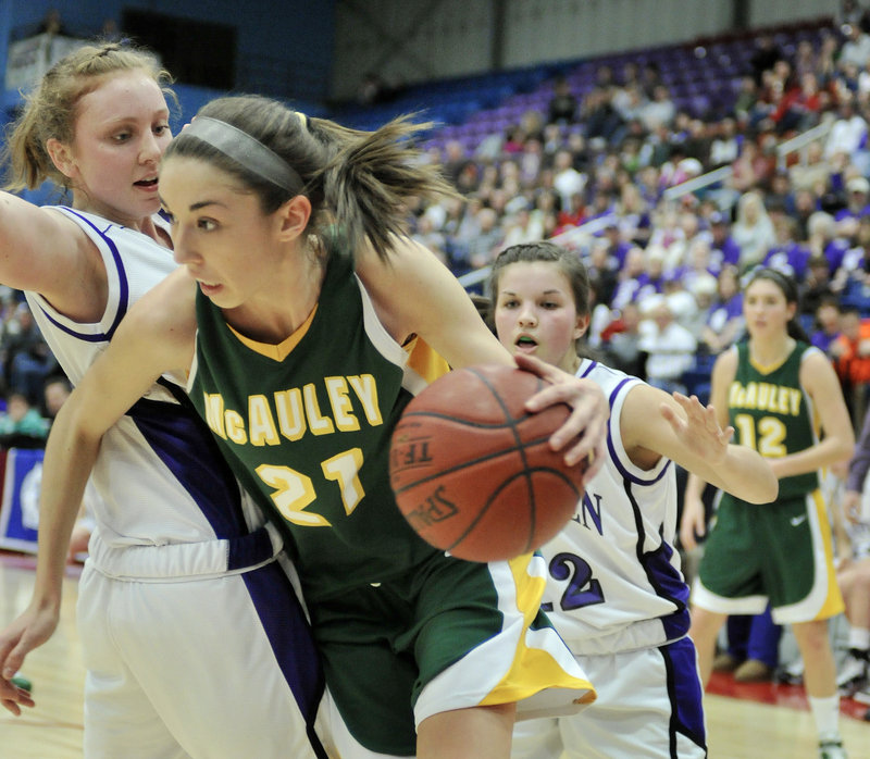 Alexa Coulombe of McAuley tries to drive past Courtney Doyon of Hampden Academy during the Class A girls’ basketball state final Saturday at the Augusta Civic Center. Coulombe had 15 points in the Lions’ 39-23 victory.
