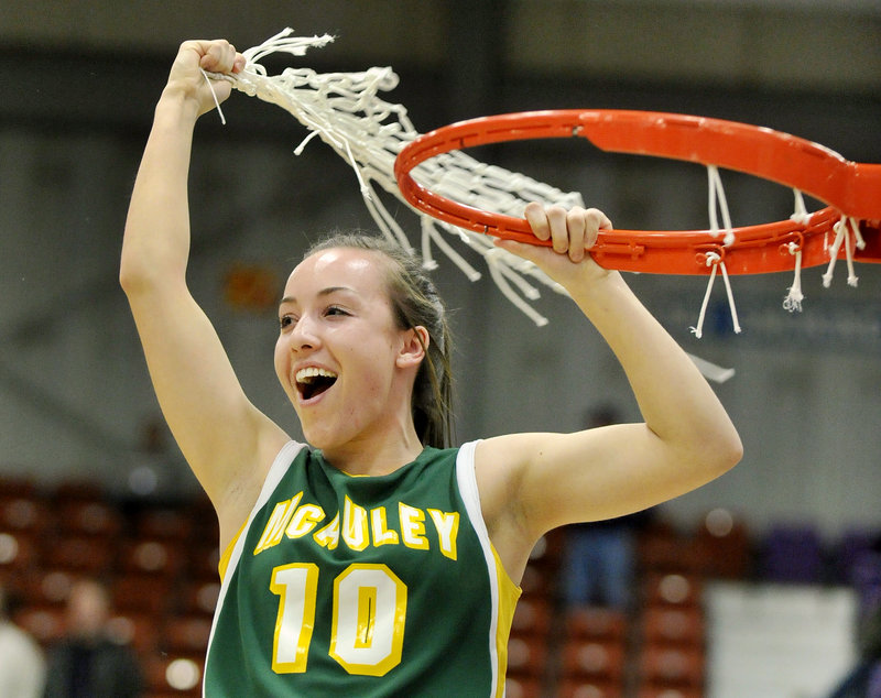 Kayla Daigle gets a fistful of net after the McAuley High basketball team beat Hampden Academy 39-23 in the Class A girls' state championship game Saturday at the Augusta Civic Center.