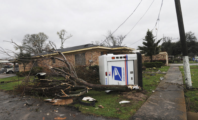 A U.S. Postal truck lies on its side in the yard of a home in Rayne, La., after a suspected tornado hit the area Saturday, injuring at least nine people.